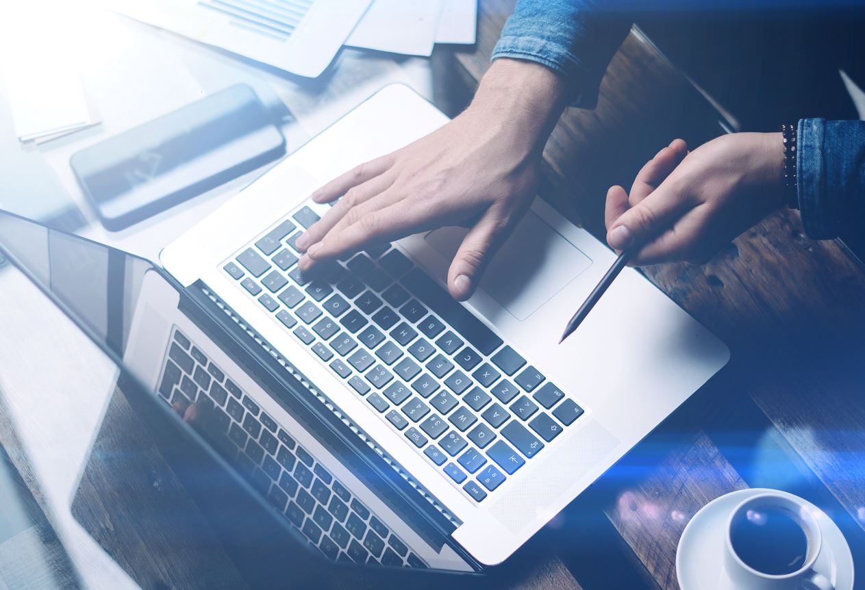 Laptop-Ansicht von oben mit einer Person, die auf der Tastatur schreibt